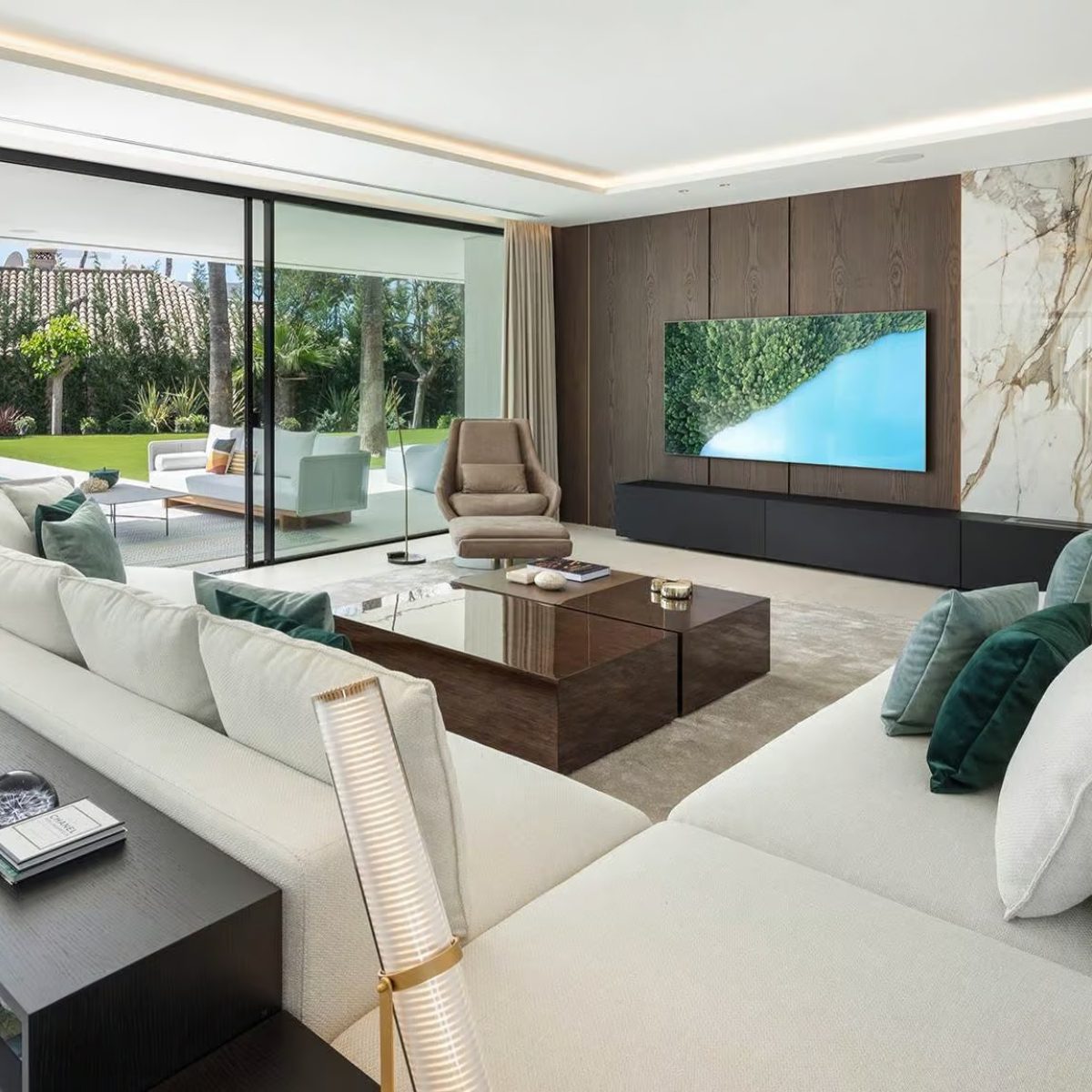 villa atalaya in marbella by blanca pera Modern living room design showcasing a large television as the focal point, complemented by stylish furniture. By Blanca Pera.